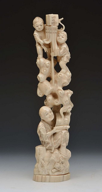 Appraisal: A JAPANESE WALRUS IVORY FIGURE GROUP depicting a seated gentleman