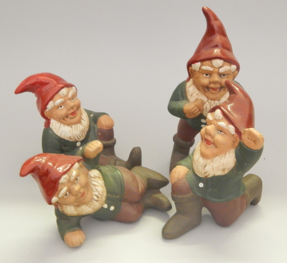 Appraisal: A set of four painted terracotta garden gnomes in various