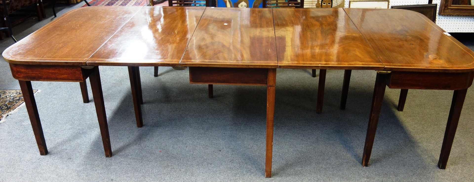 Appraisal: A George III mahogany chequer strung extending dining table with