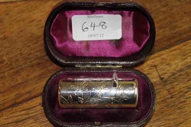 Appraisal: A SILVER PERFUME BOTTLE with engraved case of cylindrical form