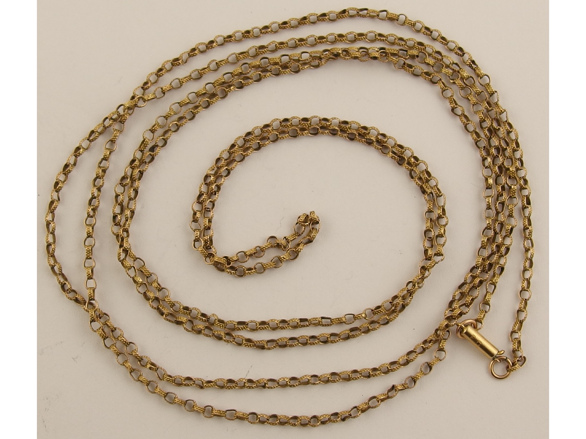 Appraisal: A long decorative yellow metal guard chain with a rolled