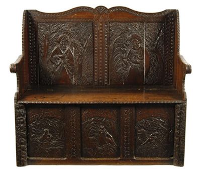 Appraisal: A carved oak settle the panelled back decorated a bearded