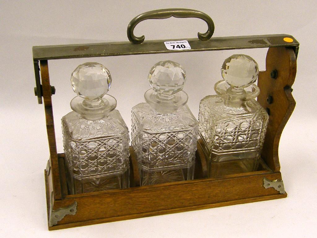 Appraisal: Benjamin's Patent oak and metal mounted three bottle tantalus patent