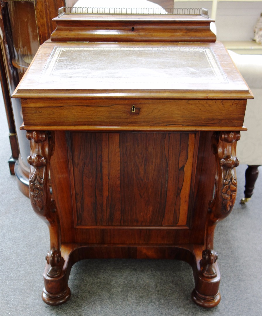 Appraisal: A Victorian rosewood Davenport with lift-top super structure over sloped