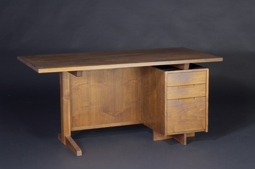 Appraisal: GEORGE NAKASHIMA Walnut three-drawer desk with grilled pandanus cloth modesty