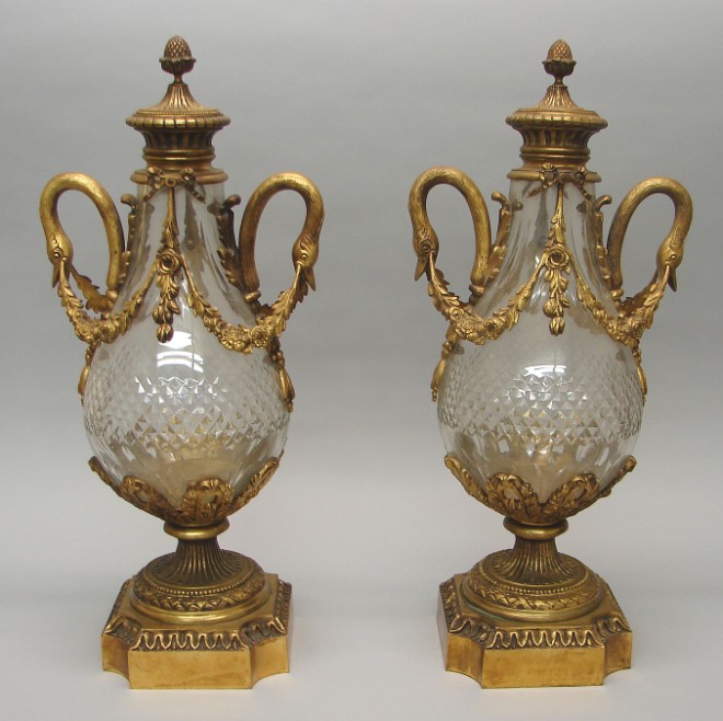 Appraisal: Urns feature swan form handles with garland motif glass central