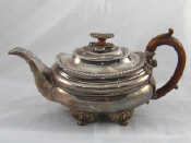 Appraisal: A Georgian silver teapot of barge form with gadrooned rim