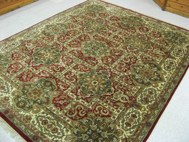 Appraisal: HAND KNOTTED ORIENTAL CARPET Indo-Persian floral medallion and flower-filled red