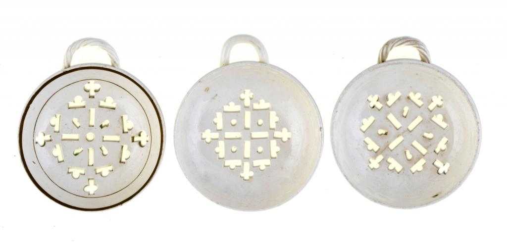 Appraisal: THREE CREAMWARE EGG DRAINERS similarly pierced one with sepia enamel