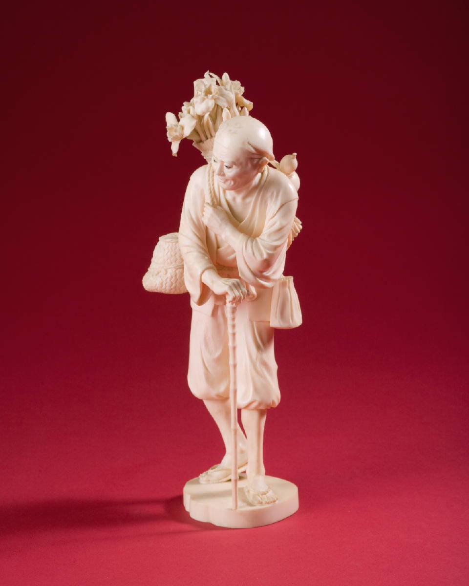 Appraisal: JAPANESE CARVED IVORY FIGURE OF A MAN HOLDING A SATCHEL