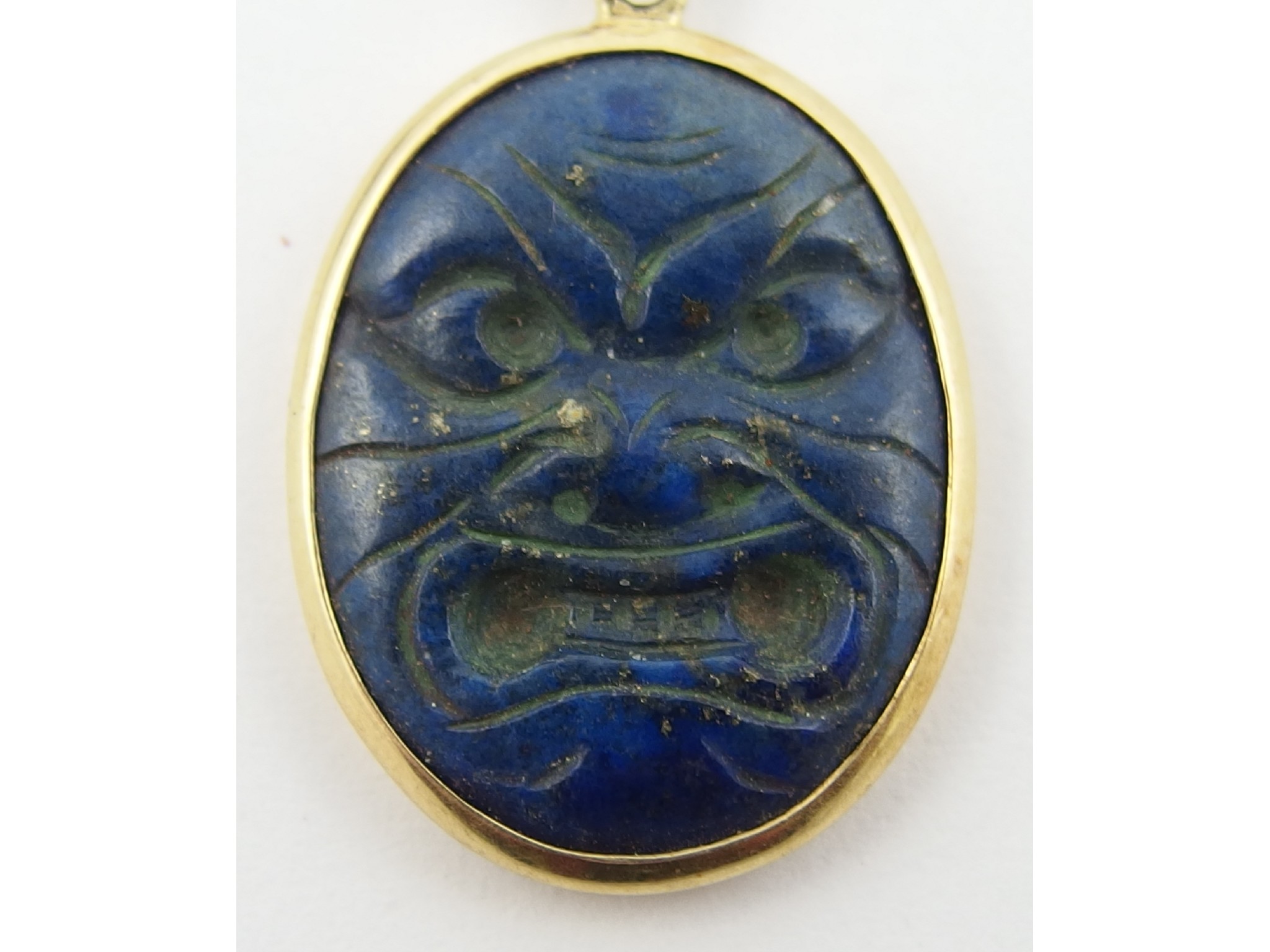 Appraisal: A carved lapis lazuli pendantcarved with an oriental mask with