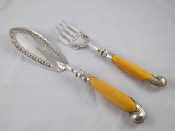 Appraisal: A pair of fish servers with silver scroll capped ivory