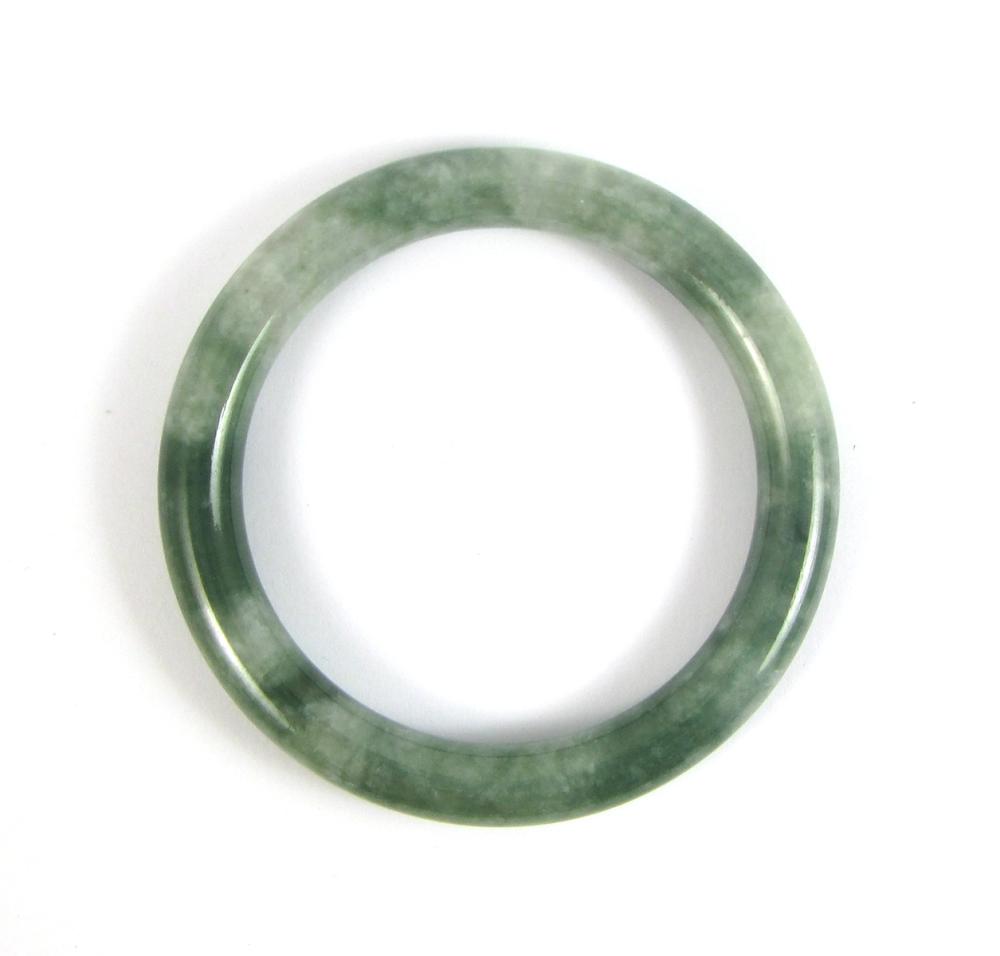 Appraisal: GREEN HARDSTONE ROUND SHAPED BANGLE The tube shaped round semi