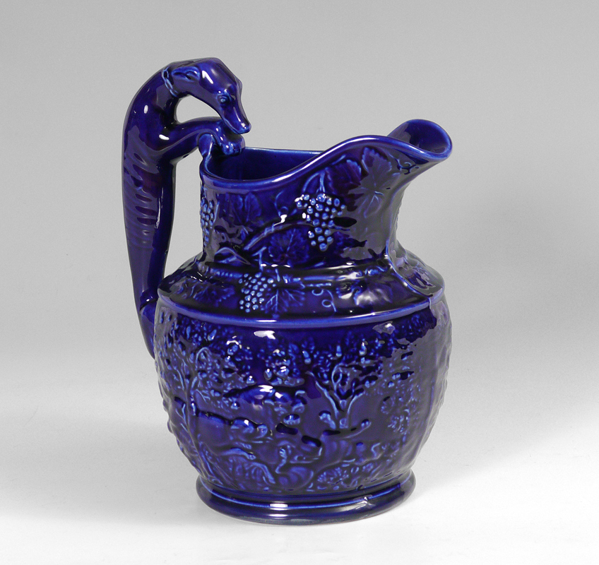 Appraisal: VANCE FAIENCE FIGURAL HOUND HANDLED PITCHER Cobalt blue glaze with