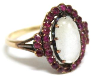 Appraisal: K Gold Moonstone Ruby Ring An oval moonstone cabochon encircled