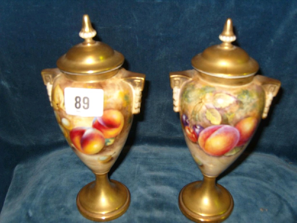 Appraisal: A pair of Royal Worcester lidded urn shaped vases with