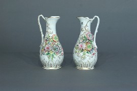 Appraisal: A pair of th century jugs with applied floral bouquets