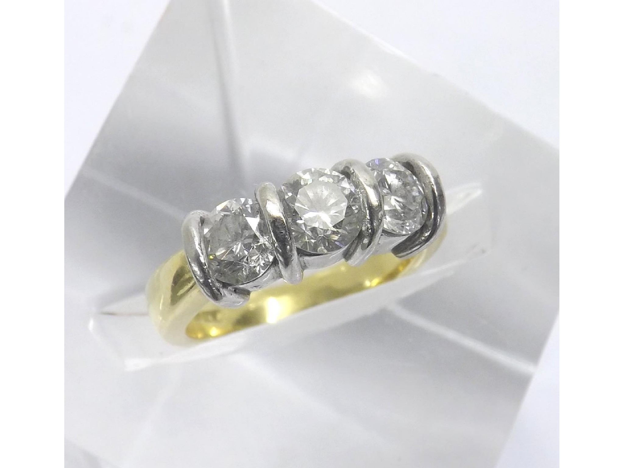 Appraisal: - -a ct yellow gold three stone tension set brilliant-cut