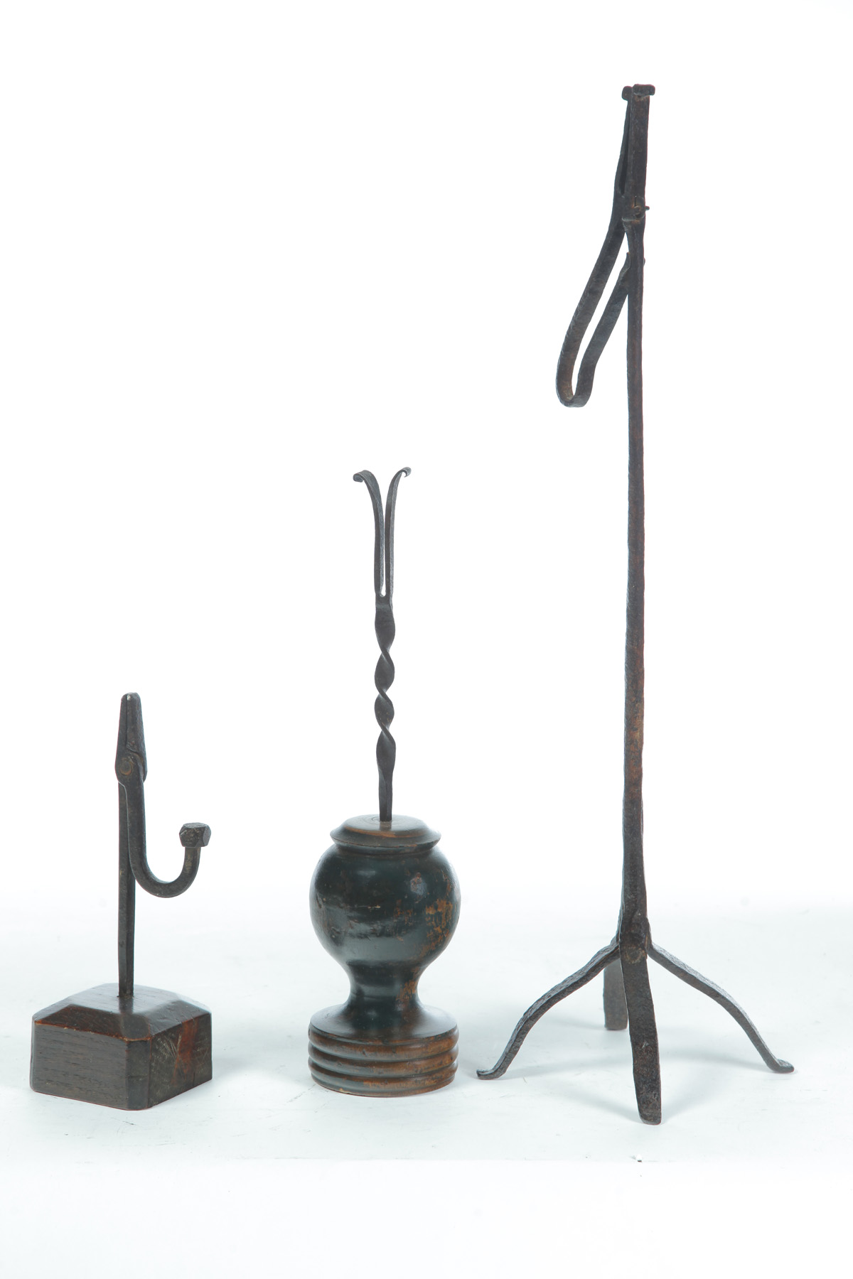 Appraisal: THREE WROUGHT IRON RUSHLIGHT HOLDERS Nineteenth century Two with wooden