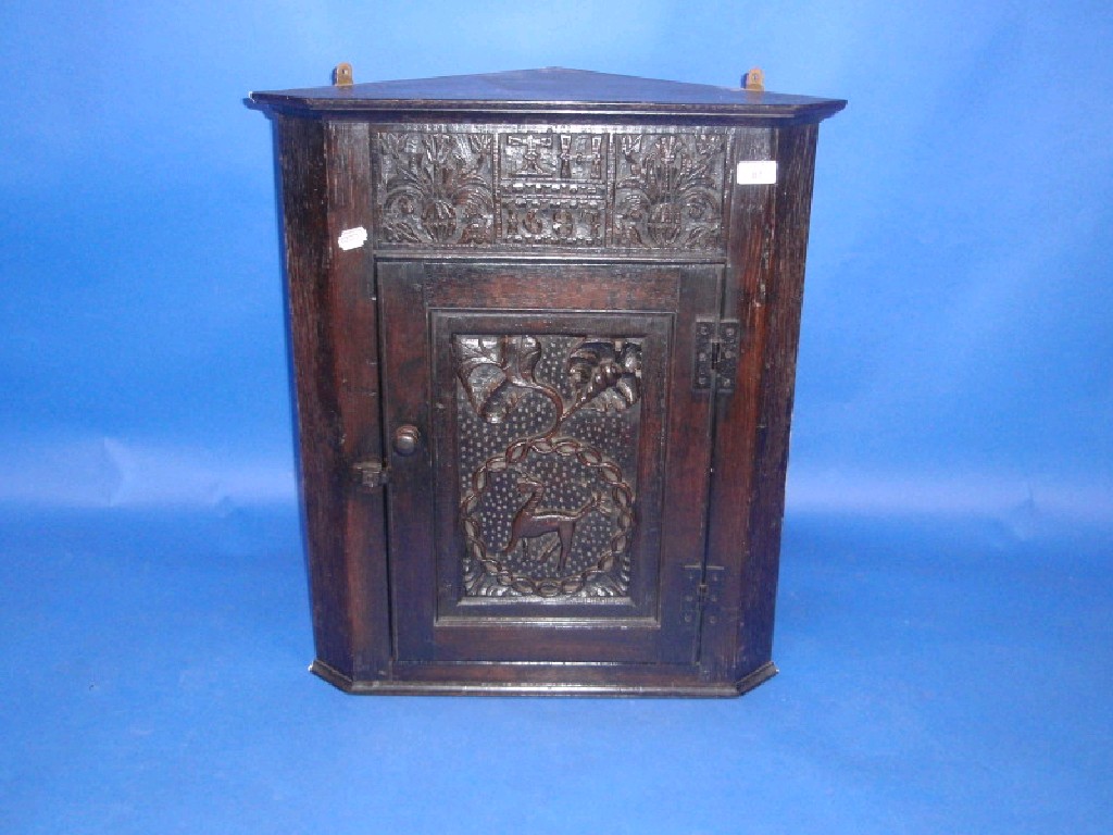 Appraisal: A carved oak hanging corner cupboard