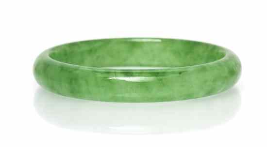 Appraisal: A Jade Bangle Bracelet measuring approximately mm wide with mottled