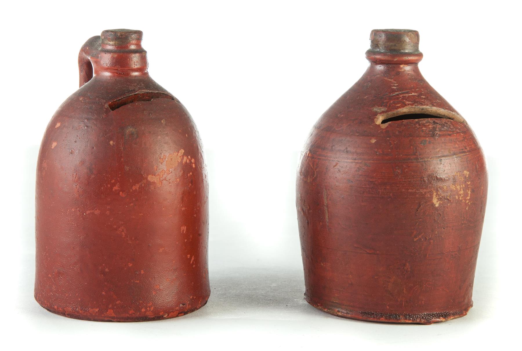 Appraisal: TWO POTTERY JUG BANKS American ca Red painted yellowware h