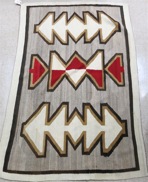 Appraisal: HAND WOVEN NAVAJO RUG the light brown field featuring three