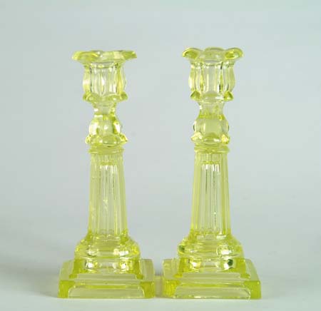 Appraisal: PAIR OF LIGHT YELLOW COLUMN SANDWICH CANDLESTICKS With stepped base