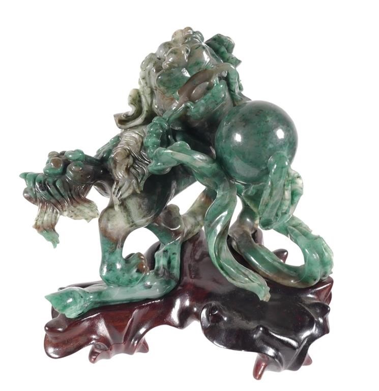 Appraisal: Carved jade foo dog with ball on a wooden base