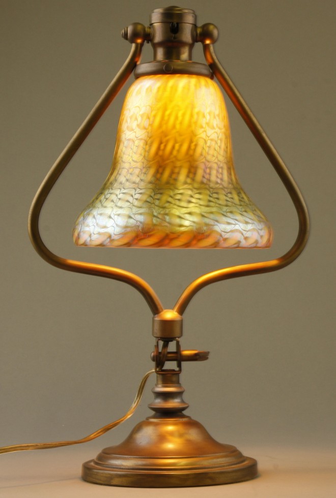 Appraisal: Art glass lamp features iridescent glass shade with metal base