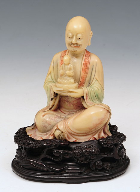 Appraisal: A CHINESE SOAPSTONE LOHAN holding a smaller buddha in his