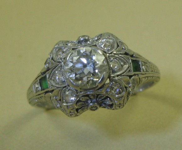 Appraisal: EMERALD DIAMOND AND PLATINUM RING centering a round-cut diamond weighing