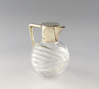 Appraisal: A late-Victorian silver mounted small claret jug of fluted globular