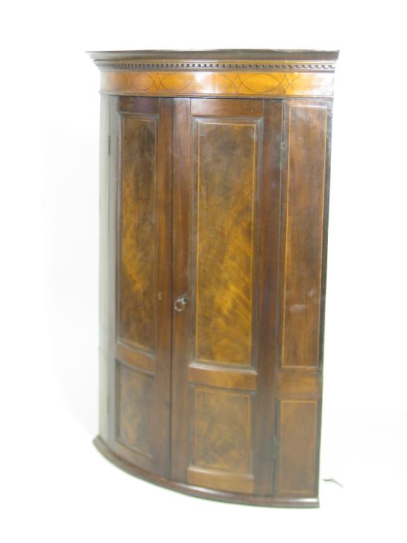 Appraisal: A th Century mahogany bow front Corner Cupboard with satinwood