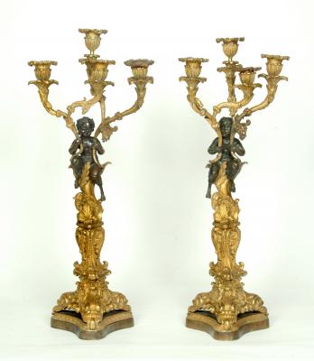 Appraisal: A PAIR OF FRENCH PATINATED AND GILT BRONZE CANDELABRA modelled