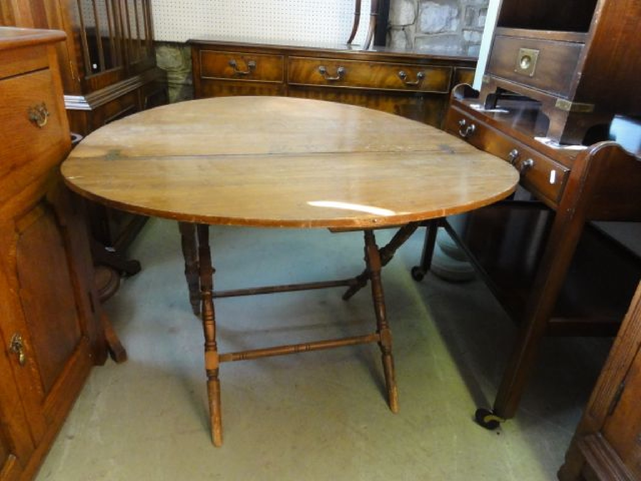 Appraisal: An Edwardian mixed wood coaching type table on folding X-framed