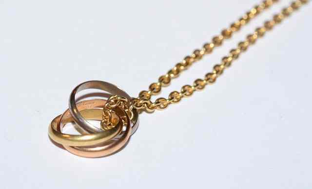 Appraisal: A GOLD NECKLACE with attached three colour gold Russian wedding