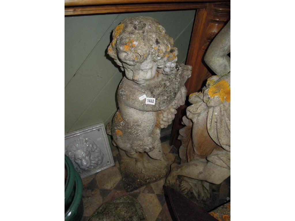 Appraisal: A weathered composition stone garden figure of a cherub holding