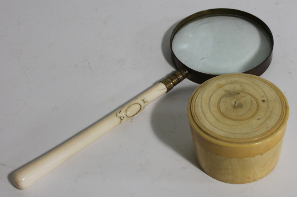 Appraisal: A Victorian magnifying glass with carved cartouche ivory handle cm