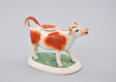 Appraisal: A Staffordshire Cow Creamer Standing on an oval mound base