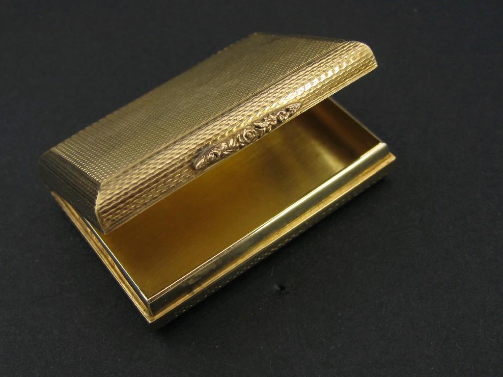 Appraisal: A ct gold oblong Box with hinged lid and engine