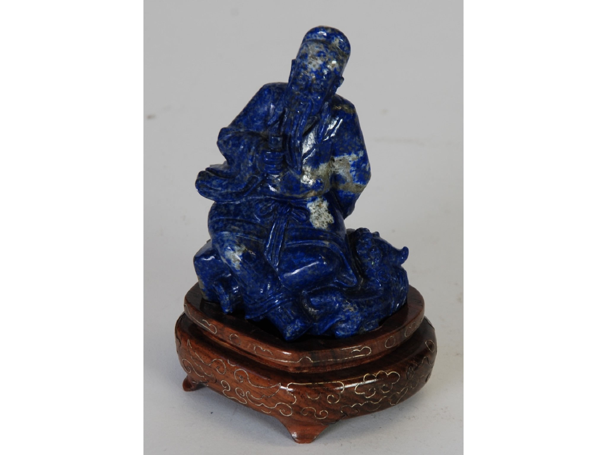 Appraisal: AN ORIENTAL CARVED SODALITE FIGURE OF A SEATED DEITY WITH