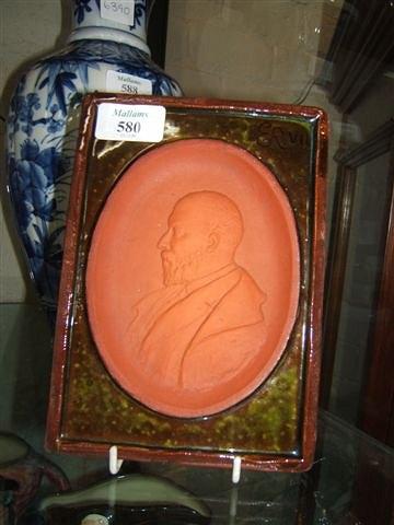 Appraisal: A U C N glazed terracotta plaque celebrating the life