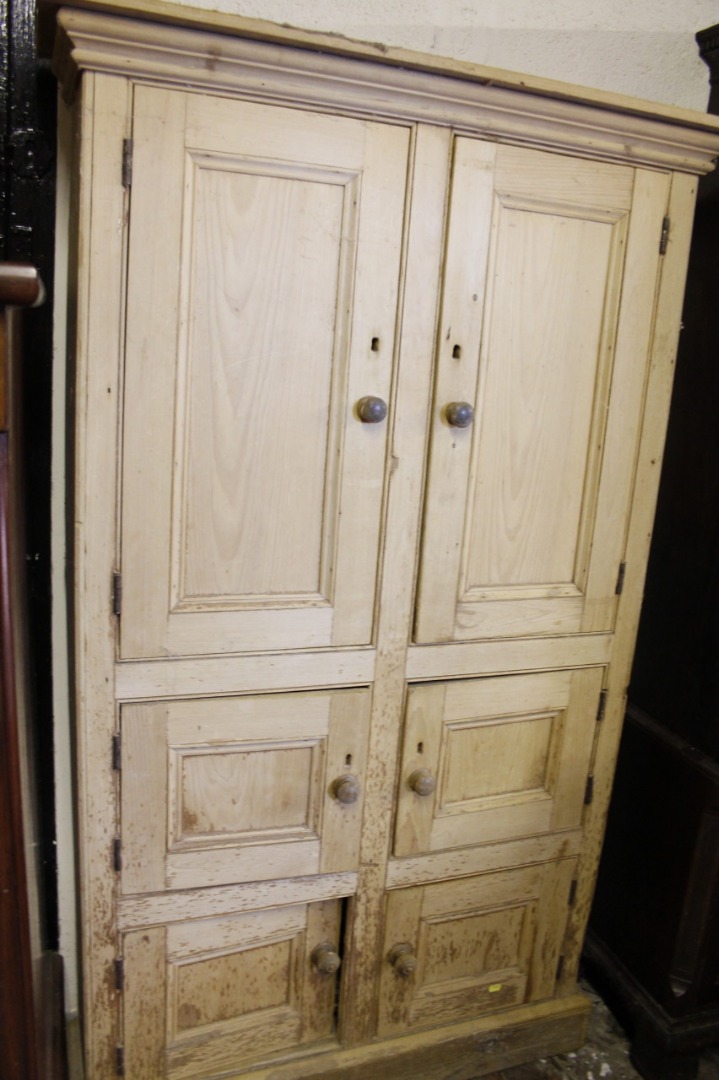 Appraisal: A stripped and lightly polished pine freestanding cupboard with two