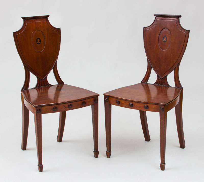 Appraisal: PAIR OF GEORGE III MAHOGANY HALL CHAIRS The backrest centered