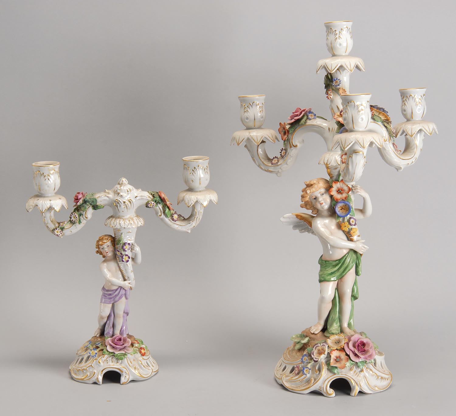 Appraisal: TWO LATE DRESDEN-STYLE CANDELABRA depicting cupids Heights and ConditionThe smallest