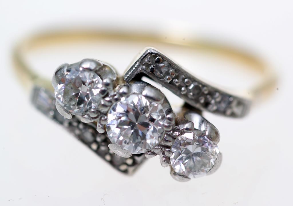 Appraisal: THREE STONE DIAMOND CROSSOVER RING with diamond-set shoulders on an