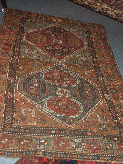 Appraisal: A SHIRAZ RUST GROUND RUG decorated double diamond central panel