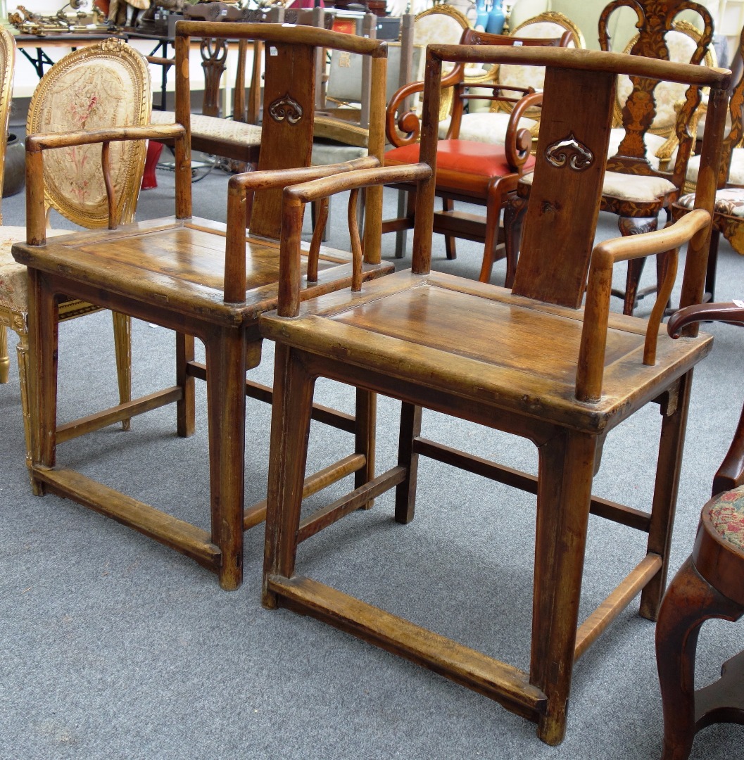 Appraisal: A pair of Chinese walnut open armchairs with pierced splat