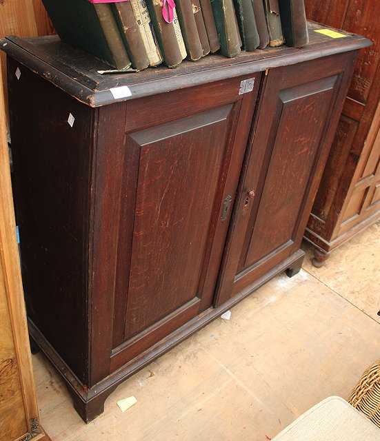 Appraisal: AN ANTIQUE OAK SIDE CABINET the twin panelled doors enclosing